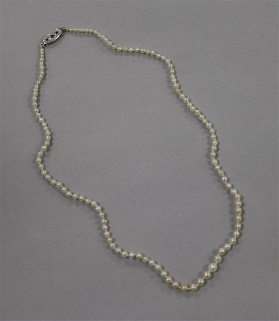 A single strand natural pearl necklace with 18ct white gold and gem set clasp and GCS certificate dated 29/6/18, 40cm.